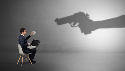 Small businessman staying and offering stuffs for an armed shadow hand
