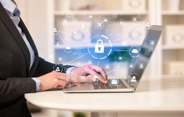 Business woman below chest working on laptop in a cozy homey environment with secured connection concept
