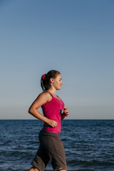Beautiful girl runs along seashore