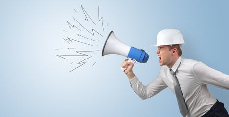 Fototapeta premium Young architect constructor yelling with megaphone and copyspace 