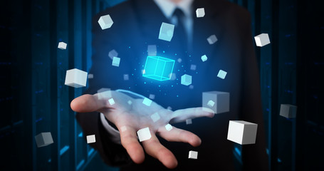 Person holding hologram projection displaying white cubes in server room
