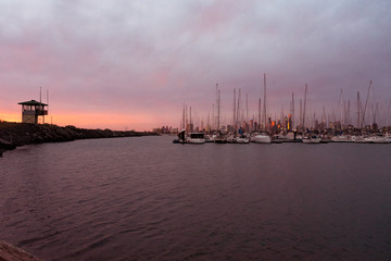 sunset on the pier of st. Kilda with boat at the harbor and Melbourne in the background