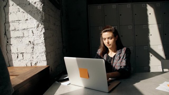 Female using laptop and working in  coworking with modern interi