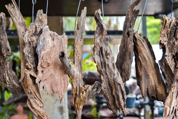 Small dried stumps for sale hanging on rail in garden