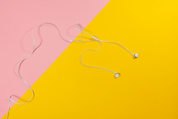 Headphones laying on a yellow and pink surface