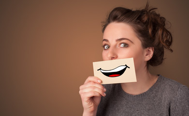 Person holding card in front of his mouth with ironic smile
