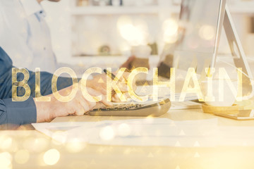 Crypto currency theme hologram with businessman working on computer on background. Concept of blockchain. Double exposure.