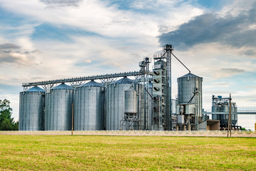 agro-processing plant for processing and silos for drying cleaning and storage of agricultural products, flour, cereals and grain with beautiful clouds