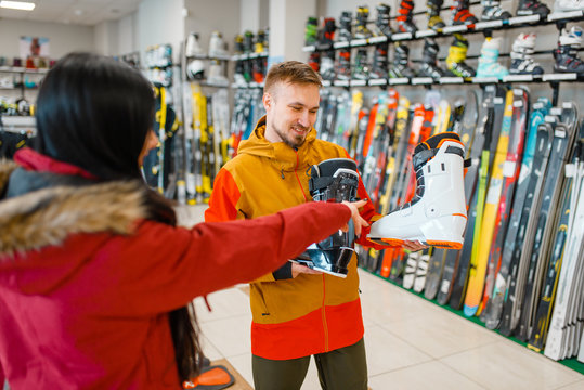 Couple choosing ski or snowboarding boots