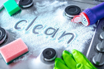 Washing and polishing gas stove using cleaning products. Spring cleaning and clean concept.