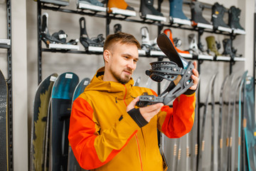 Man choosing ski boot fastening in sports shop