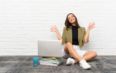 Pretty young woman sitting on the floor counting ten with fingers