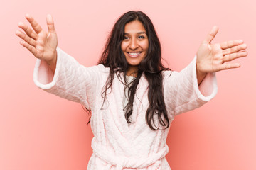 Young indian woman wearing pajama feels confident giving a hug to the camera.