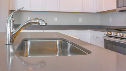 Fototapeta na wymiar Panorama frame Kitchen interior of a new house with close up view of the shiny faucet and sink