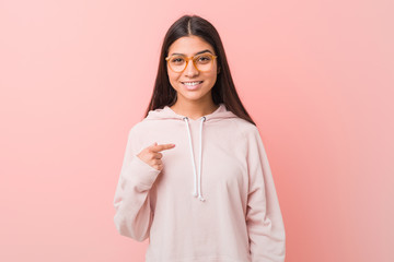 Young pretty arab woman wearing a casual sport look person pointing by hand to a shirt copy space,...
