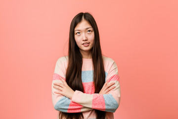 Obraz premium Young cool chinese woman tired of a repetitive task.