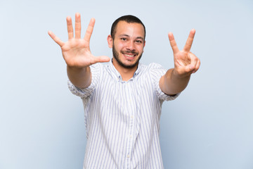 Colombian man over isolated blue wall counting seven with fingers