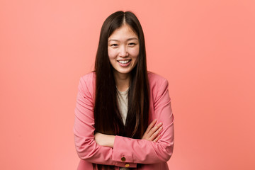 Young business chinese woman wearing pink suit laughing and having fun.