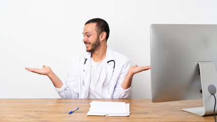 Doctor Colombian man holding copyspace with two hands