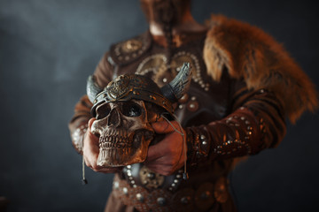 Viking holds human skull in helmet