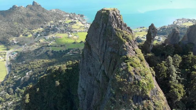 Aerial drone parallax shot of the high cliff of Mount Manaia overlooking the ocean and villages below in Whangarei Heard New Zealand