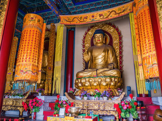 Golden buddha statue in Tianmen Temple Hall on tianmen mountain zhangjiajie city China.Tianmen...