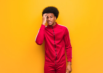 Young sport black man over an orange wall worried and overwhelmed