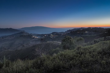 sunrise at Nor Lae Hill Tribes Village, beautiful top hills around with many mountains, green forest and yellow sun light in the sky background, Doi Ang Khang, Chiang Mai, Thailand.
