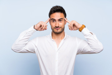 Naklejka premium Handsome young man over isolated blue background having doubts and thinking