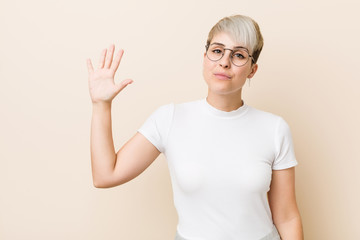 Young authentic natural woman wearing a white shirt smiling cheerful showing number five with fingers.