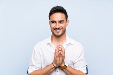 Handsome young man over isolated blue background scheming something