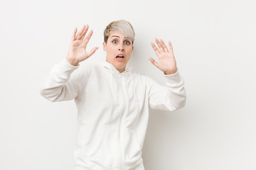 Young curvy woman wearing a white hoodie being shocked due to an imminent danger