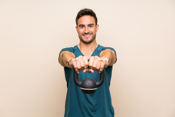 Handsome sport man over isolated background with kettlebell