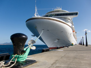 A low angle view of a cruise ship tied to its mooring in the caribbean. 