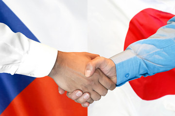 Business handshake on the background of two flags. Men handshake on the background of the Czech Republic and Japan flag. Support concept