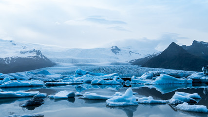 Glacier lake with icebergs with mountain and glacier in the background in Fjallsárlón, Iceland