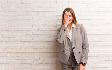 Young russian business woman shouting happy and covering face with hand