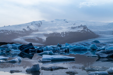 Glacier lake with icebergs with mountain and glacier in the background in Fjallsárlón, Iceland