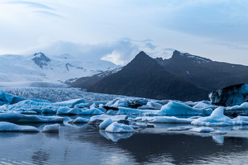 Glacier lake with icebergs with mountain and glacier in the background in Fjallsárlón, Iceland