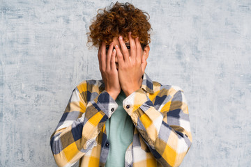 Fashion african american over grunge wall covering eyes and looking through fingers