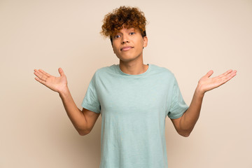 African american man with green shirt having doubts while raising hands