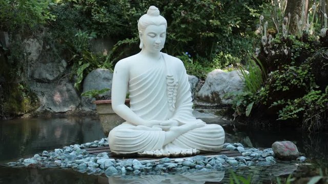 White buddha in the nature. Buddhist statue - yoga concept
