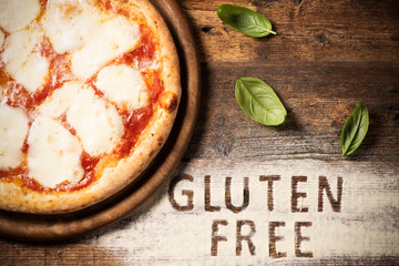 A gluten free pizza on a rustic wood background