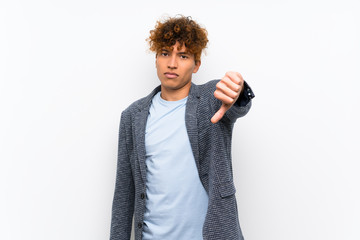 Naklejka premium Fashion african american man over isolated white wall showing thumb down with negative expression