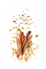 Food concept assortment Oriental spices cardamom pods, coriander seeds, fennel and Cinnamon Cassia Bark Sticks on white background with copy space