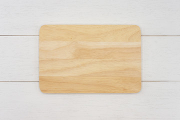 Empty rectangle wooden cutting board on white wooden table. Top view image.