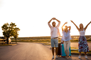 Three friends are on the road and try to stop a free taxi because they need transportation to the hotel. © borevina