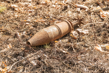 unexploded rusty projectile in the forest