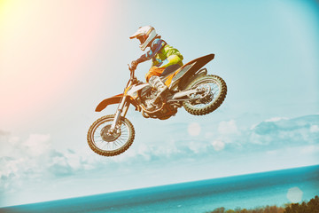 Extreme sports, motorcycle jumping. Motorcyclist makes an extreme jump against the sky. Extreme sports, motorcycle jumping. Motorcyclist makes an extreme jump against the sky. Special processing under