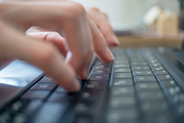 Fingers of a girl close-up on a laptop. Woman using a laptop, searching the Internet, viewing information, home workplace, soft focus